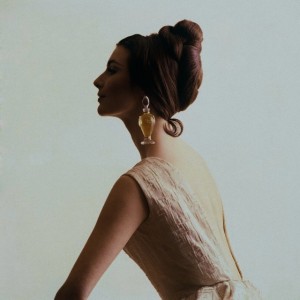 1964, Profile view of a model wearing a bottle of Diorissimo by Dior perfume bottle as an earring.