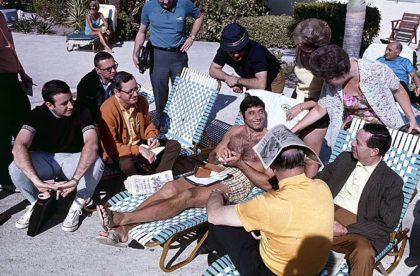 New York Jets quarterback Joe Namath lounges by the pool with press and fans before Super Bowl III. Photographed by Walter Iooss Jr. for Sports Illustrated